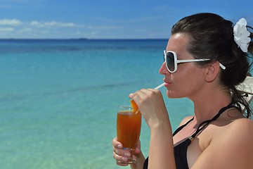 Image showing Beautiful young woman with a drink by the sea