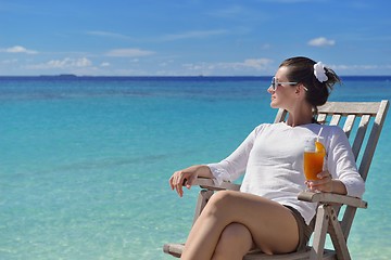 Image showing Beautiful young woman with a drink by the sea