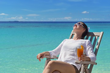 Image showing Beautiful young woman with a drink by the sea