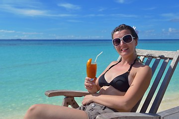 Image showing Beautiful young woman with a drink by the sea