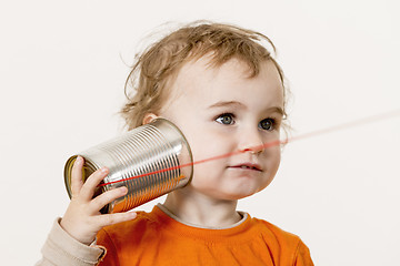 Image showing young child listening to tin can phone