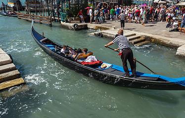 Image showing ITALY, VENICE - JULY 2012: Gondolas with tourists cruising a small Venetian canal on July 16, 2012 in Venice. Gondola is a major mode of touristic transport in Venice, Italy. 