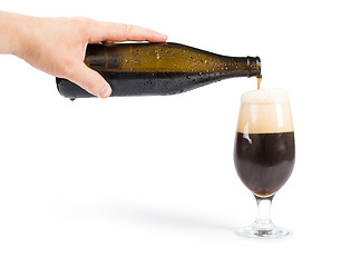Image showing Hand holding bottle of beer and beer mug