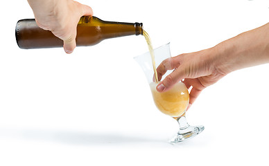 Image showing Hand holding bottle of beer and beer mug