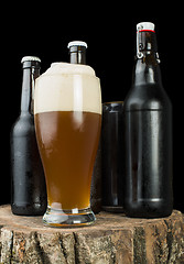 Image showing Bottles of beer and beer mug on stump