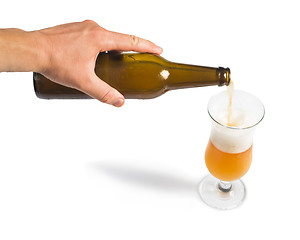 Image showing Hand holding bottle of beer and beer mug