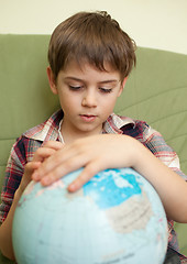 Image showing Little boy looking at globe