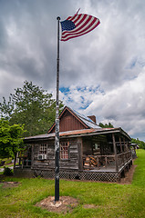 Image showing old log cabin and american flag