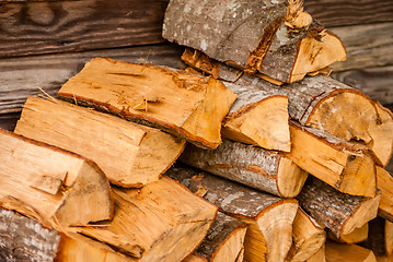 Image showing chopped fire wood next to log cabin