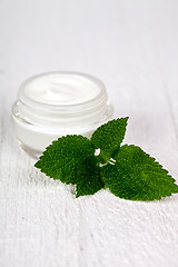 Image showing face cream in glass jar with green leaf of urtica