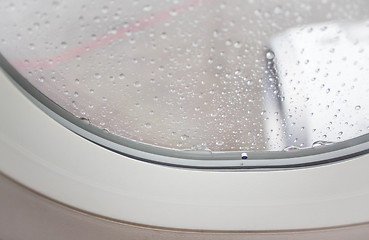 Image showing Veritable rain drops on aircraft window and jet engine view