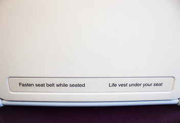 Image showing Airplane seat back with caution inform on flight