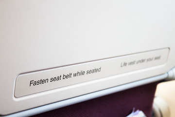 Image showing Airplane seat back with caution inform on the flight