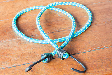 Image showing Light blue rubber band with metal hooks
