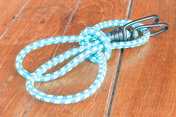 Image showing Light blue elastic rope on wood background