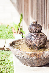 Image showing Earthenware garden jar with water spring on sunlight 