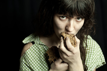 Image showing beggar woman eating bread 