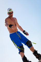 Image showing young man with inline skates in summer outdoor 