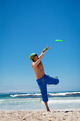 Image showing attractive man playing frisby on beach in summer