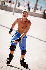 Image showing young man with inline skates in summer outdoor 