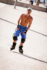 Image showing young man with inline skates in summer outdoor 