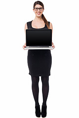 Image showing Saleswoman presenting brand new laptop