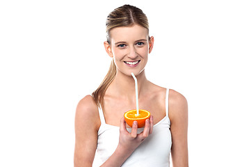 Image showing Girl sipping orange juice through straw