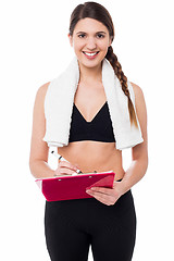 Image showing Fit lady trainer preparing diet chart