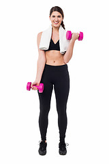 Image showing Fitness female instructor lifting dumbbells