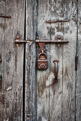 Image showing Rusty padlock on an old wooden door of the house