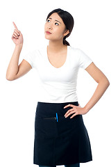 Image showing Asian waitress pointing and looking away