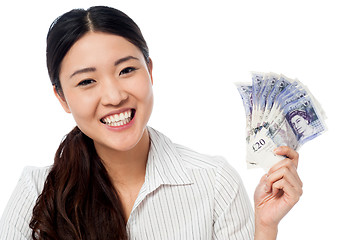 Image showing Pretty woman holding a fan of currency notes