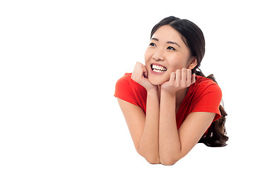 Image showing Girl lying on studio floor and thinking something