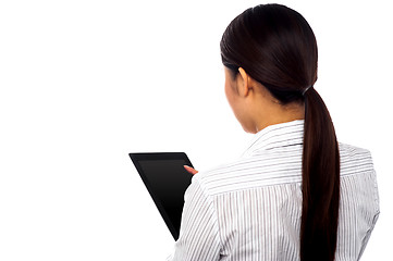 Image showing Back pose of a woman operating touch pad device