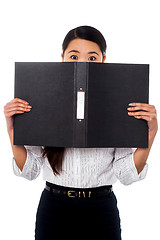 Image showing Woman hiding her face with a business file