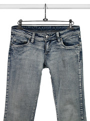 Image showing Blue jeans on a closet rod