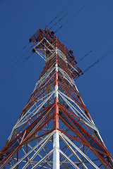 Image showing Red and white electricity pylon against the blue sky