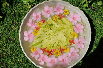 Image showing water cup with beautiful flowers background