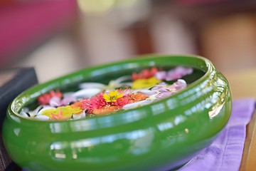 Image showing water cup with beautiful flowers background