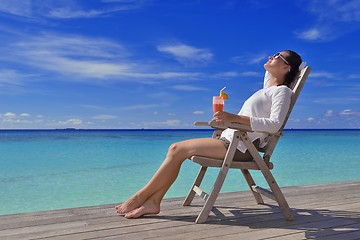 Image showing Beautiful young woman with a drink by the sea