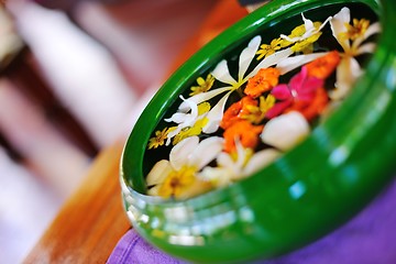 Image showing water cup with beautiful flowers background