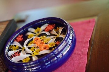 Image showing water cup with beautiful flowers background