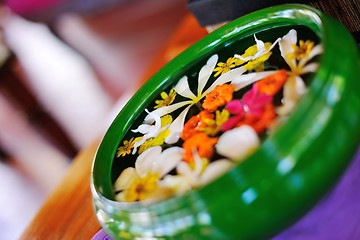 Image showing water cup with beautiful flowers background