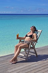 Image showing Beautiful young woman with a drink by the sea