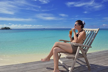 Image showing Beautiful young woman with a drink by the sea