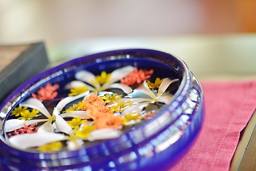 Image showing water cup with beautiful flowers background