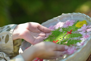 Image showing female hand and flower in water