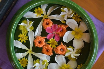 Image showing water cup with beautiful flowers background