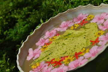 Image showing water cup with beautiful flowers background