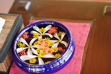 Image showing water cup with beautiful flowers background